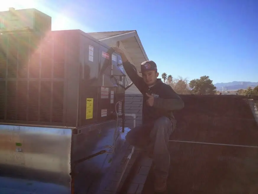 HVAC technician performing HVAC Inspection on a rooftop unit in Schodack